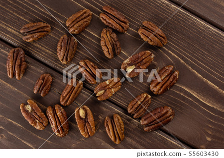 Fresh pecan nut on brown wood Fresh pecan nut on brown wood 55603430