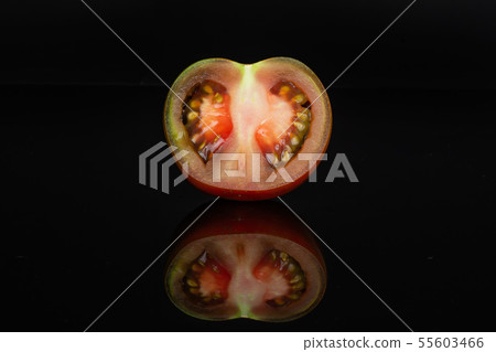 Greenish red tomato isolated on black glass 55603466