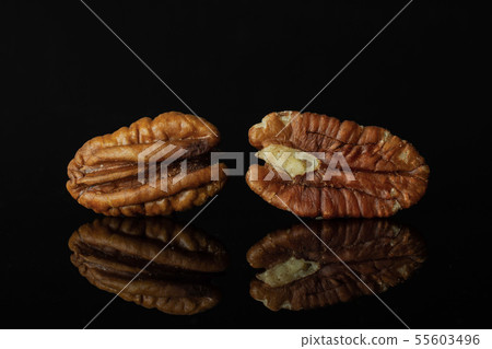 Fresh pecan nut isolated on black glass Fresh pecan nut isolated on black glass 55603496
