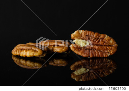 Fresh pecan nut isolated on black glass Fresh pecan nut isolated on black glass 55603500