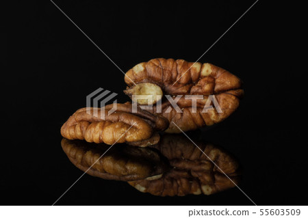 Fresh pecan nut isolated on black glass Fresh pecan nut isolated on black glass 55603509