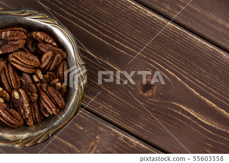 Fresh pecan nut on brown wood Fresh pecan nut on brown wood 55603558
