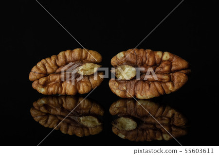 Fresh pecan nut isolated on black glass 55603611