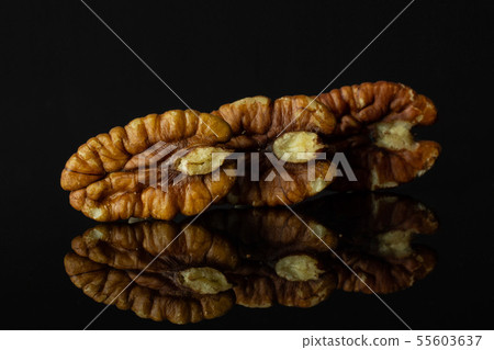 Fresh pecan nut isolated on black glass 55603637