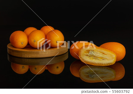 Fresh orange kumquat isolated on black glass Fresh orange kumquat isolated on black glass 55603792
