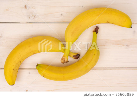 Ripe yellow banana on grey wood 55603889