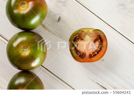 Greenish red tomato on grey wood 55604241