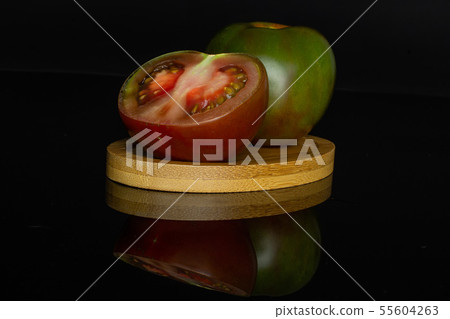 Greenish red tomato isolated on black glass 55604263