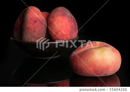 Fresh paraguay peach isolated on black glass Fresh paraguay peach isolated on black glass 55604288