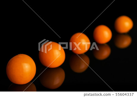 Fresh orange physalis isolated on black glass Fresh orange physalis isolated on black glass 55604337