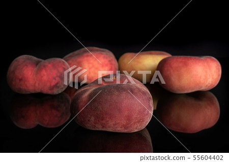 Fresh paraguay peach isolated on black glass Fresh paraguay peach isolated on black glass 55604402