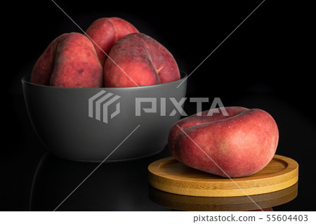 Fresh paraguay peach isolated on black glass Fresh paraguay peach isolated on black glass 55604403