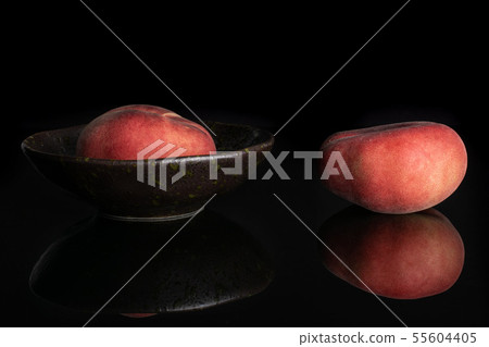Fresh paraguay peach isolated on black glass Fresh paraguay peach isolated on black glass 55604405