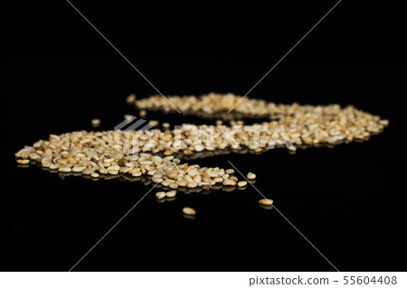 Unpeeled sesame seeds isolated on black glass Unpeeled sesame seeds isolated on black glass 55604408