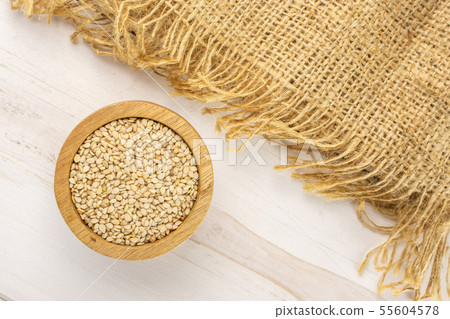Unpeeled sesame seeds on grey wood Unpeeled sesame seeds on grey wood 55604578