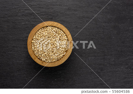 Unpeeled sesame seeds on grey stone 55604586