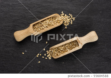Unpeeled sesame seeds on grey stone Unpeeled sesame seeds on grey stone 55604588