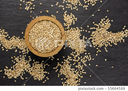 Unpeeled sesame seeds on grey stone Unpeeled sesame seeds on grey stone 55604589