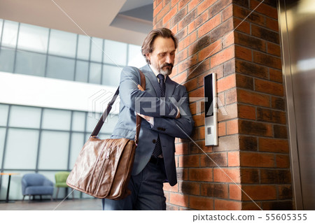 Bearded businessman hating waiting near the elevator 55605355