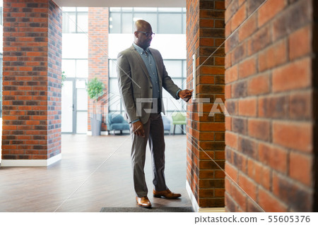 Young businessman wearing glasses standing near elevator 55605376
