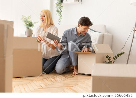Gladful Couple Unpacking Boxes After Moving Into New Apartment 55605485
