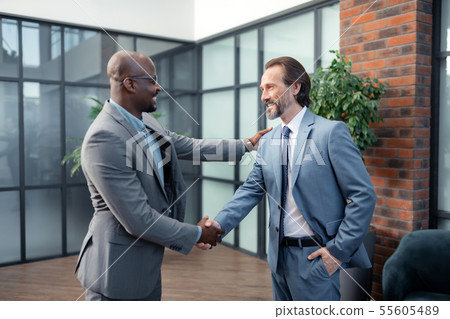 Investor smiling while meeting his business partner Investor smiling while meeting his business partner 55605489