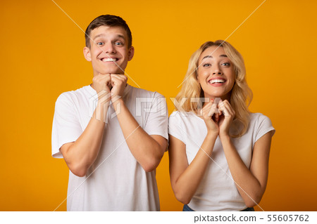 Young couple pleading for something and keeping hands together 55605762