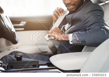 African-american businessman fastening seat belt in car African-american businessman fastening seat belt in car 55605815