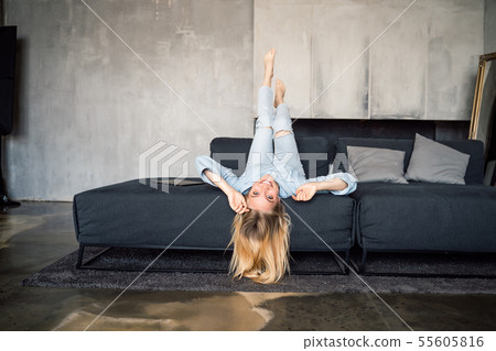 Woman enjoying on a couch with head upside down. Woman enjoying on a couch with head upside down. 55605816