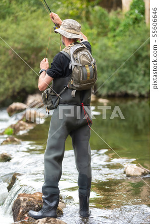 Fisherman fishing on the River, holding Fishing Rod. 55606646