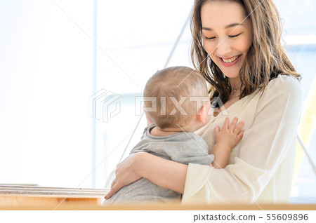 A woman holding a child 55609896