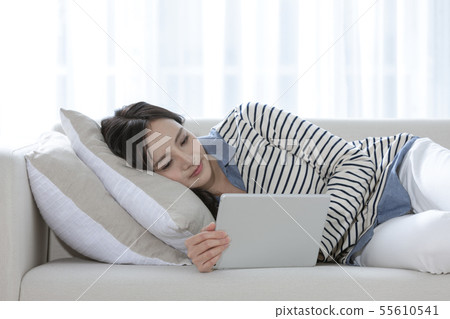 A woman watching a tablet PC A woman watching a tablet PC 55610541