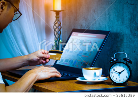 man holding credit card for e-shopping at night 55615389