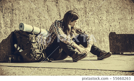 Man tourist backpacker sitting by grunge wall 55668263