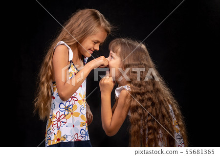 Girl pinched a hand on the nose of another girl Girl pinched a hand on the nose of another girl 55681365
