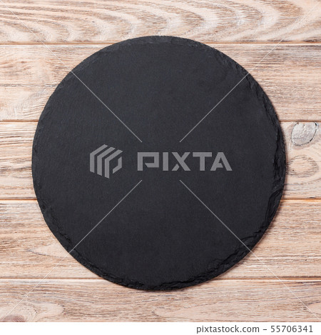 Round plate on table. black dish on wooden Round plate on table. black dish on wooden 55706341