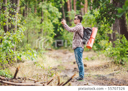 Man hiker taking photo smart phone in forest. Attractive Traveler Making Photo With Mobile Phone 55707326