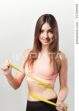 Hands to measure the waist tape. Diet. Healthy Eating. Young sports girl. The concept of health and Hands to measure the waist tape. Diet. Healthy Eating. Young sports girl. The concept of health and 55709405
