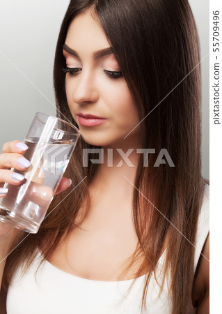 Drink water. Young girl drinking water from the glass. Daily water intake. Clean water. The concept Drink water. Young girl drinking water from the glass. Daily water intake. Clean water. The concept 55709496