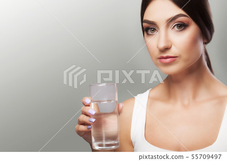 Drink water. Young girl drinking water from the glass. Daily water intake. Clean water. The concept 55709497