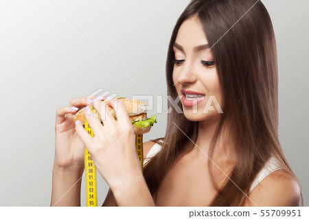Young girl eating food, burger fast food, American unhealthy dietary calorie Concept of health and Young girl eating food, burger fast food, American unhealthy dietary calorie Concept of health and 55709951