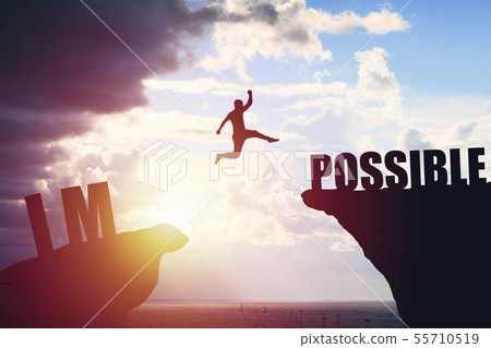 Man jumping over impossible or possible over cliff on sunset background 55710519