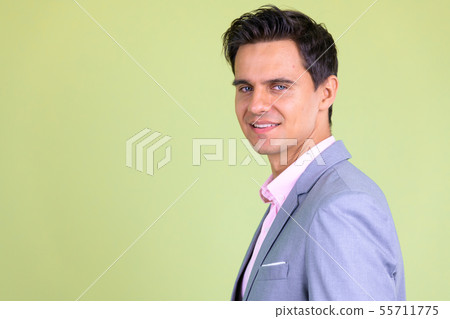 Closeup profile view of happy young handsome businessman looking at camera 55711775