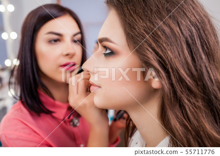 beauty and makeup concept - closeup portrait of beautiful woman getting professional make-up with beauty and makeup concept - closeup portrait of beautiful woman getting professional make-up with 55711776