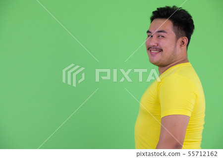 Profile view of happy young overweight Asian man smiling Profile view of happy young overweight Asian man smiling 55712162