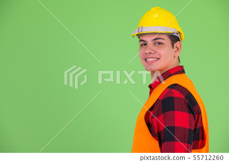 Profile view of happy young multi ethnic man construction worker looking at camera 55712260