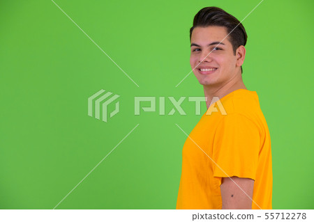 Profile view of happy young multi ethnic man smiling and looking at camera 55712278