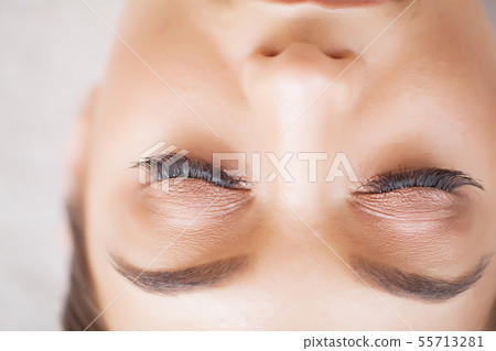 Woman Eye with Long Eyelashes. Beautiful Young Woman During Eyelash Extension 55713281