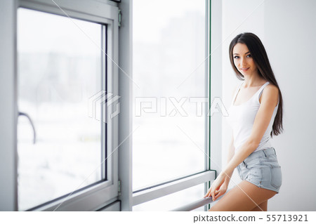 Beautiful woman standing near windows. Beautiful morning. Beautiful woman standing near windows. Beautiful morning. 55713921
