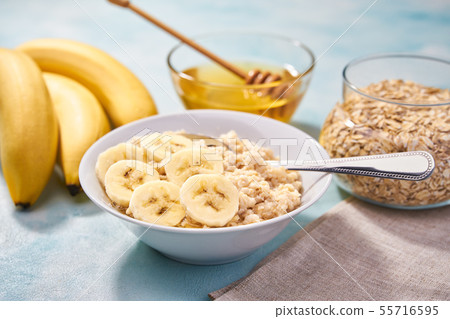 Freshly cooked oatmeal with banana and honey on a Freshly cooked oatmeal with banana and honey on a 55716595